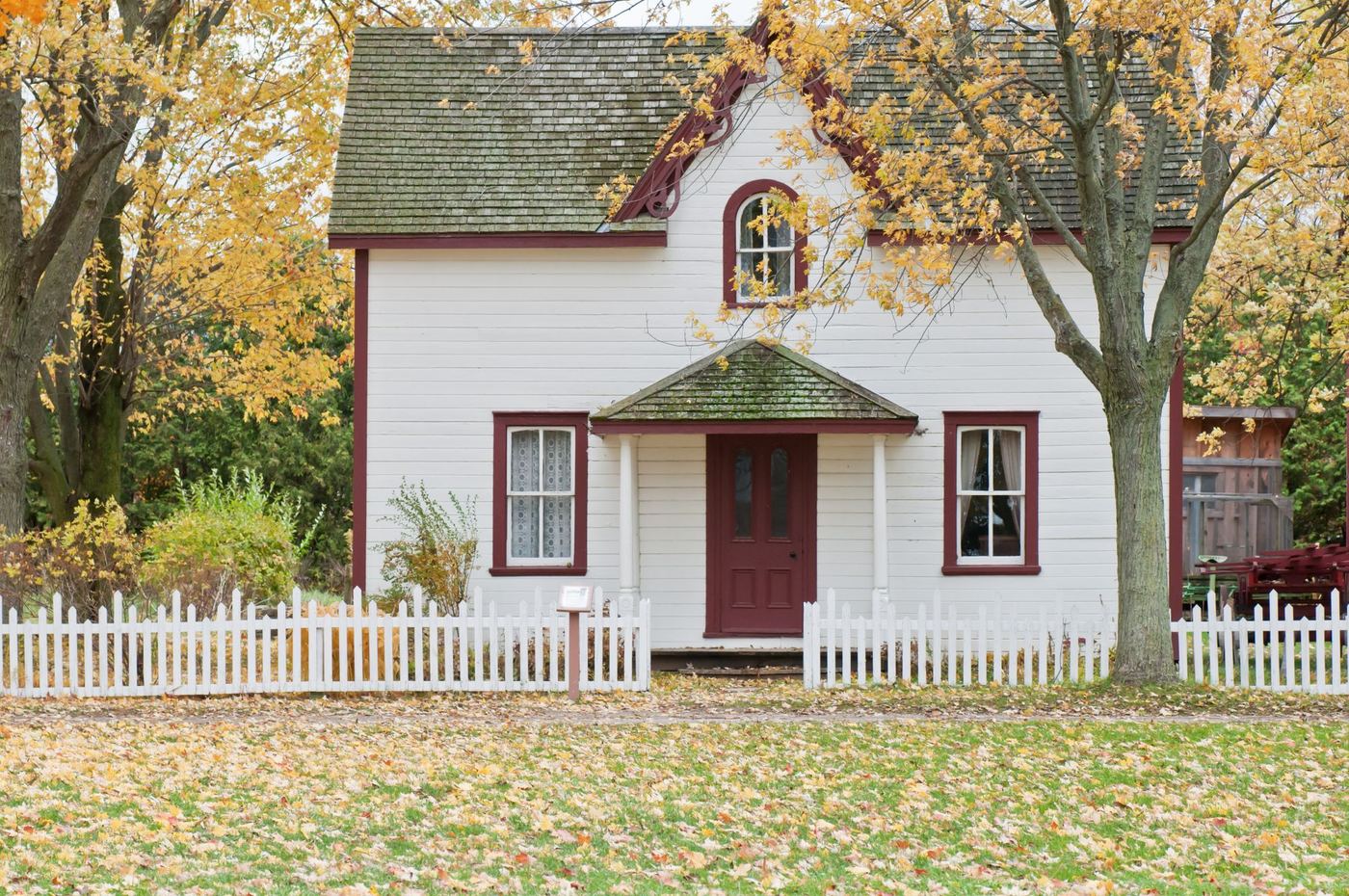 White farmhouse-style home with a picket fence