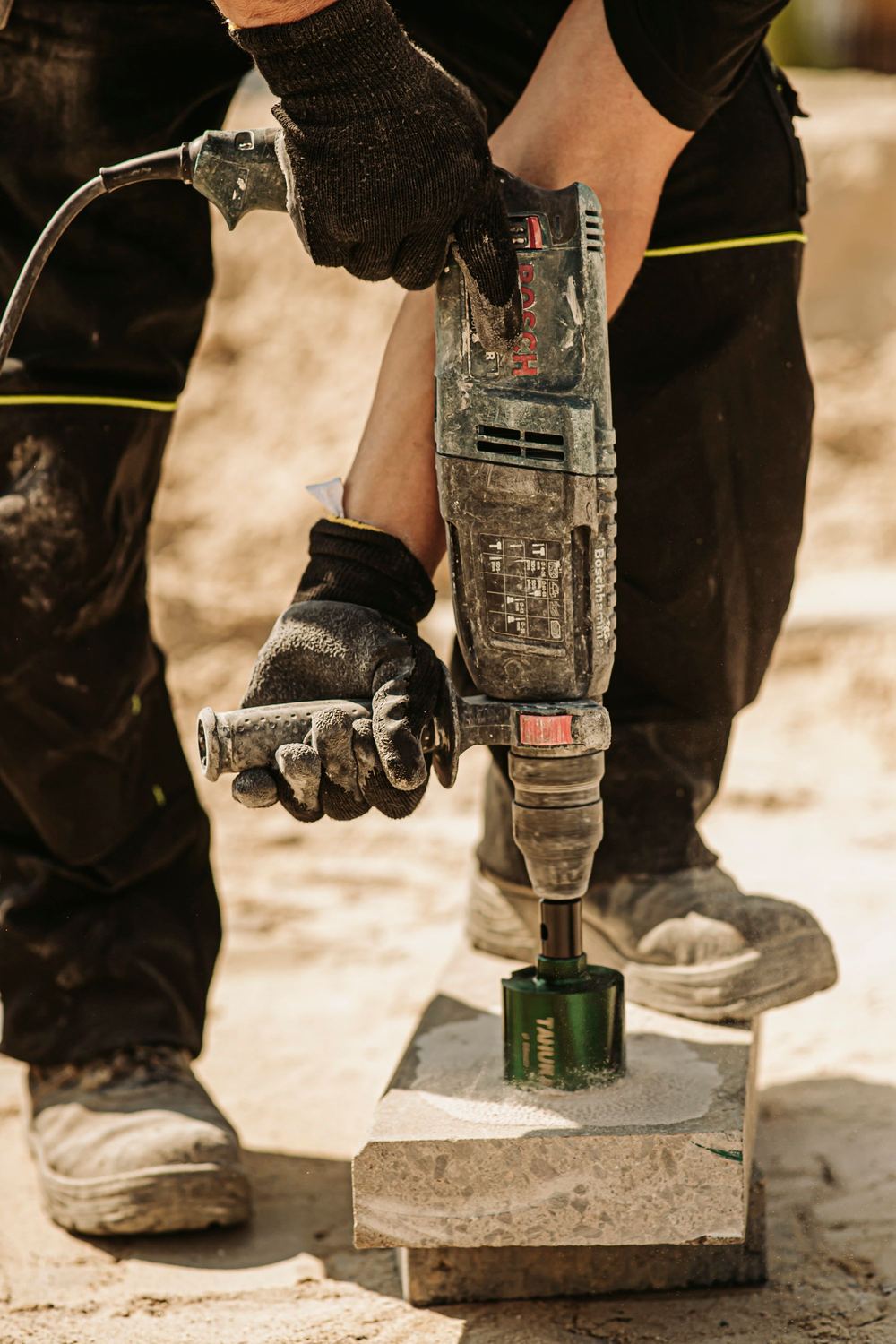 Installer drilling through concrete with a core drill bit