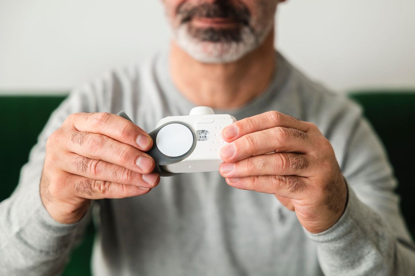 Man holding a small handheld air monitoring device