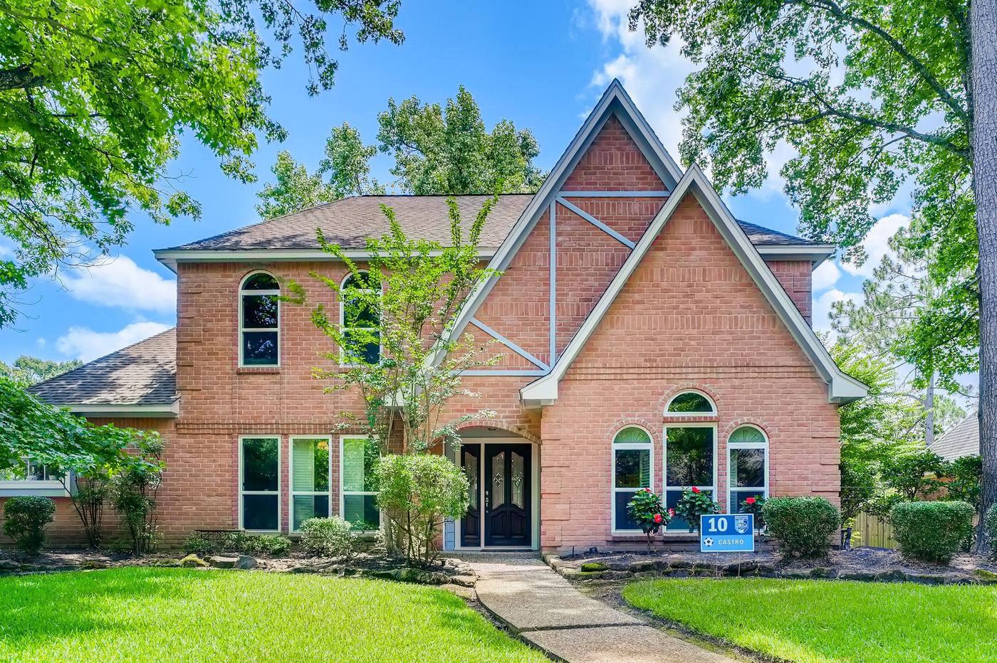 Brick home with a For Sale sign in the front yard